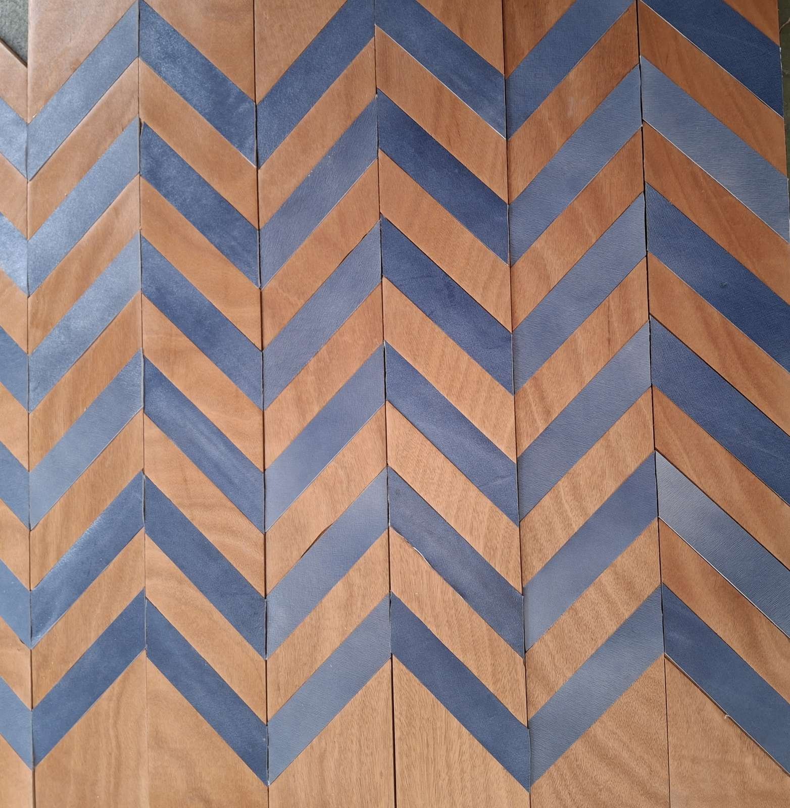 Pavimento a spina ungherese con doghe in legno chiaro alternate a strisce in pelle blu