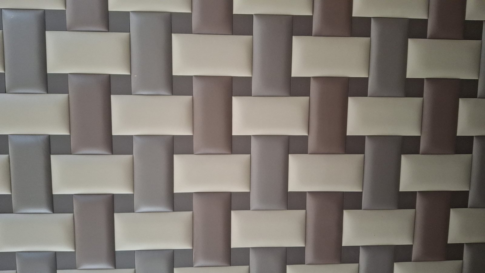 Rivestimento a intreccio con listelli imbottiti nei toni crema, tortora e grigio