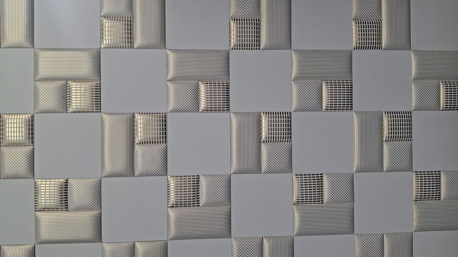 Rivestimento murale a scacchiera con quadrati lisci alternati a texture rigata e a rete metallica